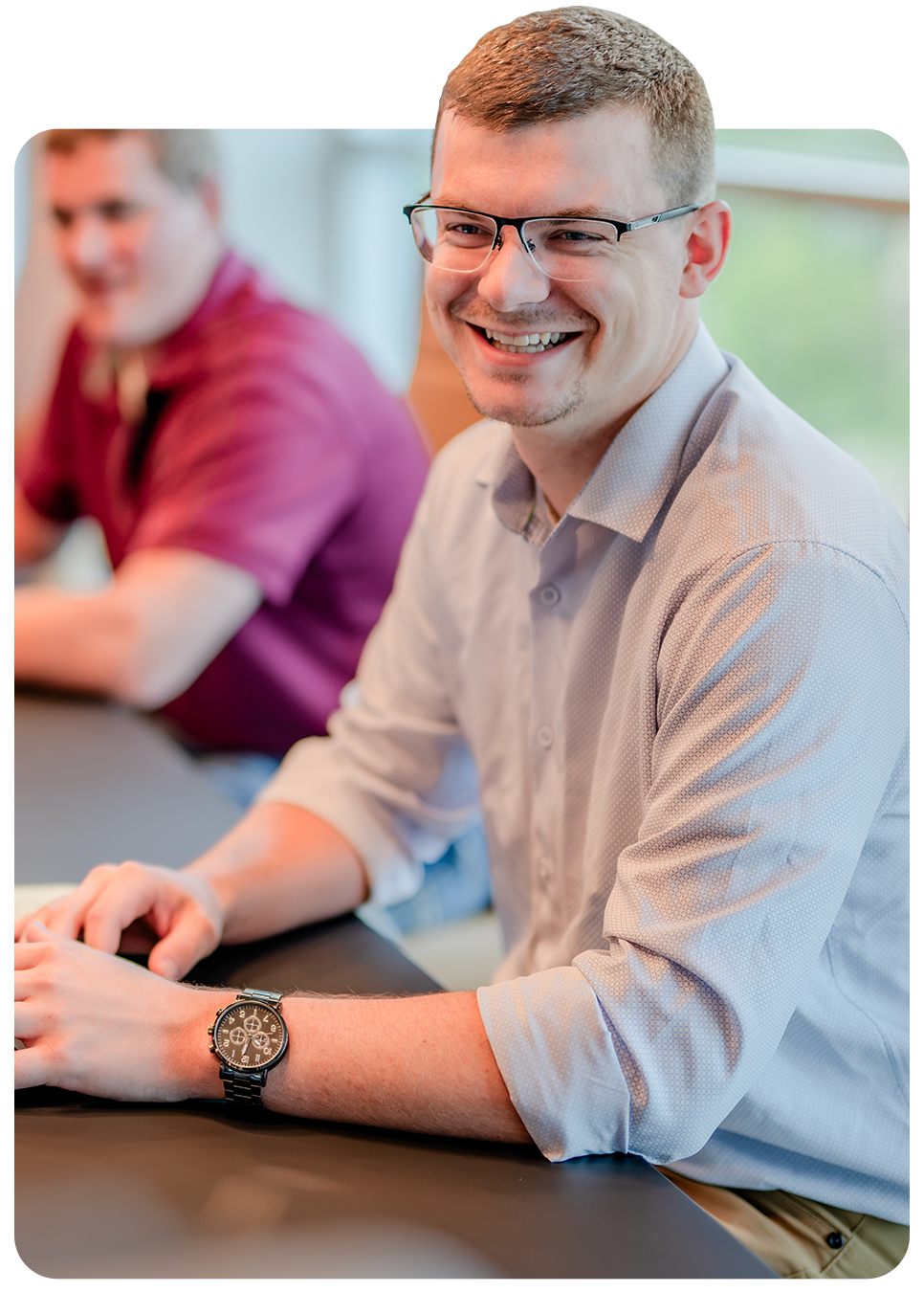 A smiling Miron office professional seated at a conference table