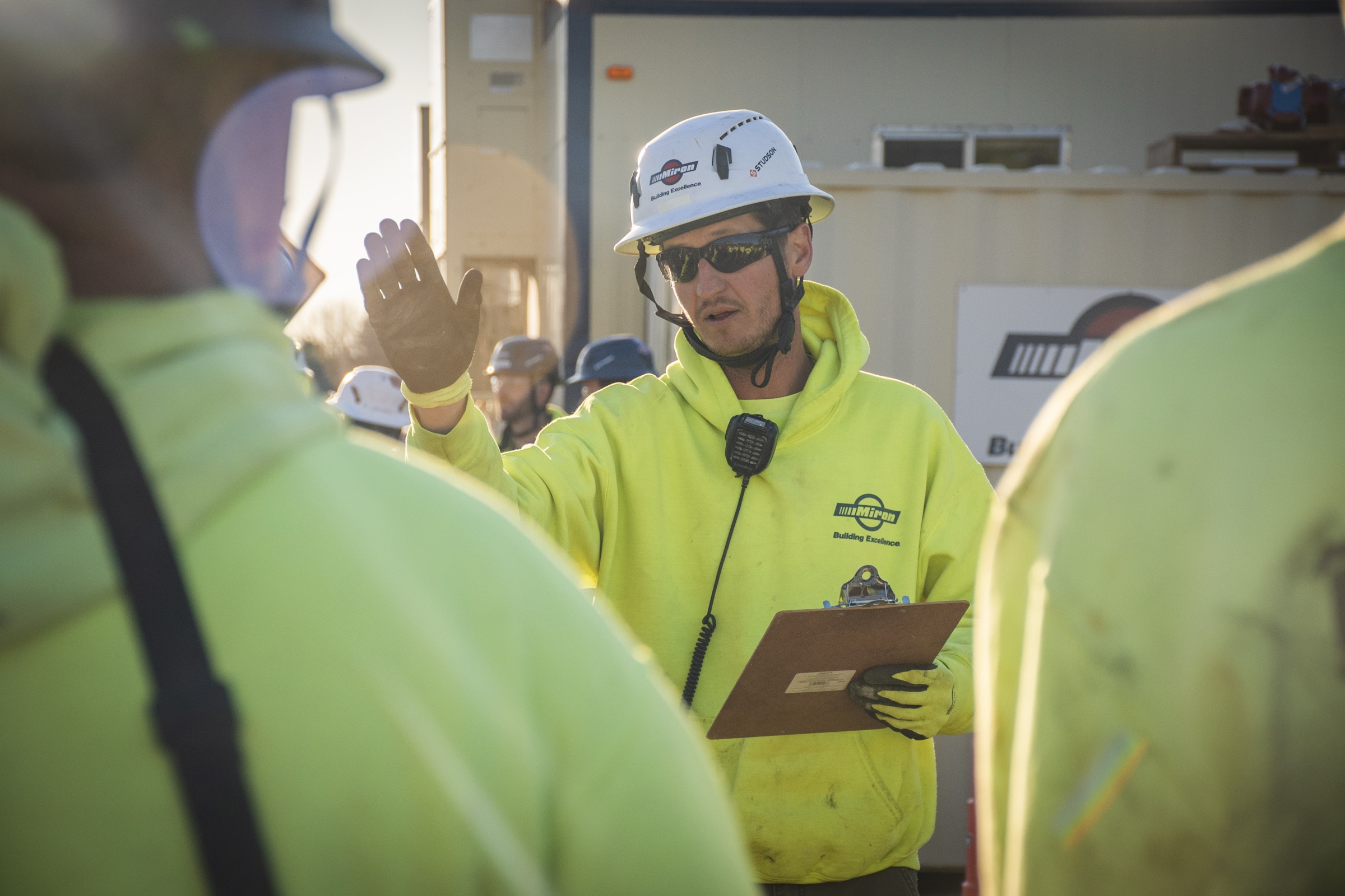Miron crew leader holding a clipboard and leading a safety briefing