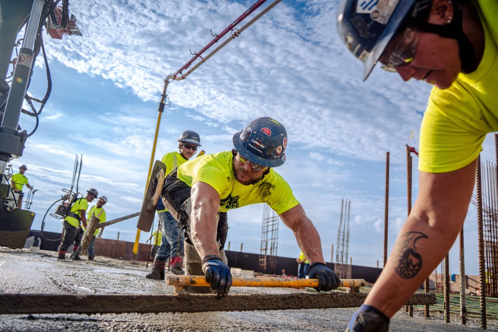 Miron cement finishers screeding fresh concrete on a deck pour