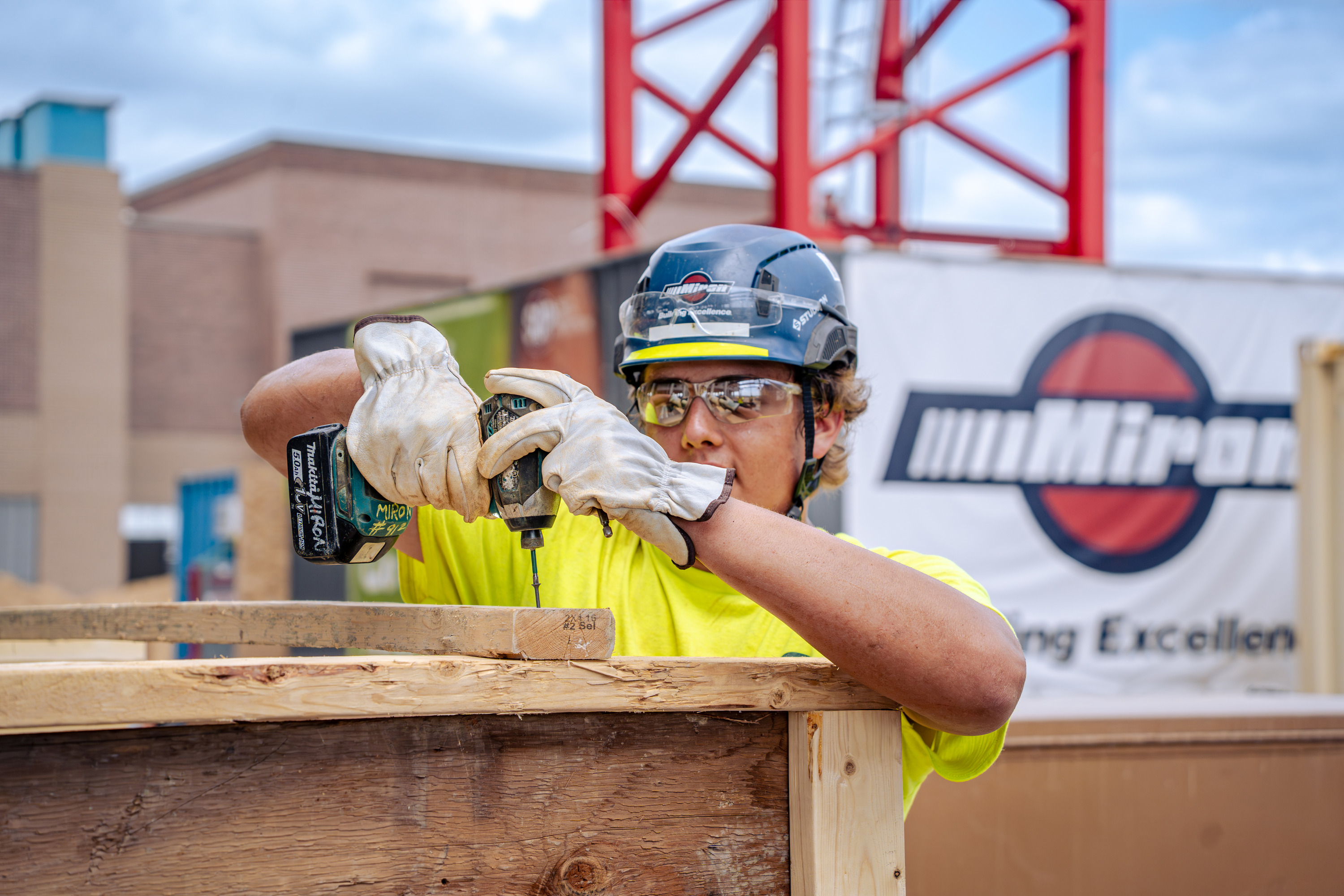 Youth apprentice driving a screw into a wood form with a power drill