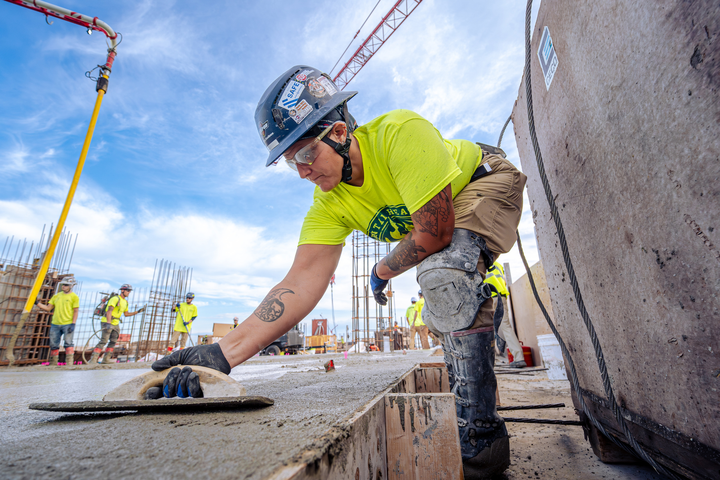 Youth apprentice finishing a concrete surface with a trowel