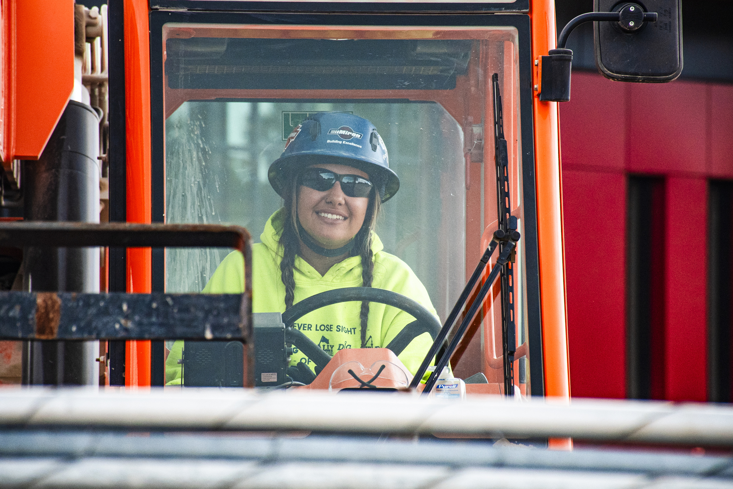 Smiling youth apprentice in the cab of heavy equipment
