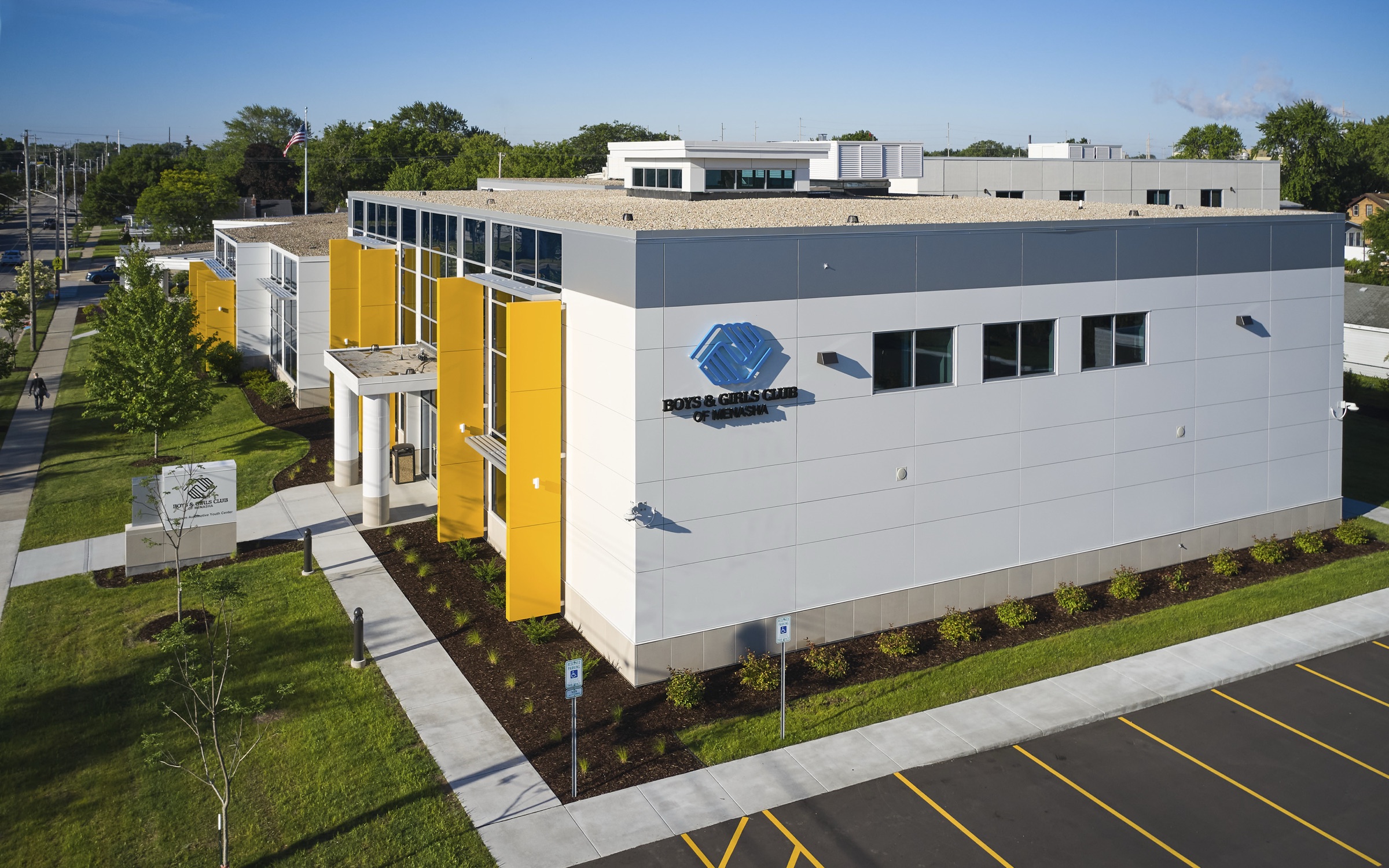 Boys & Girls Club building with yellow fins and a blue logo on its white facade