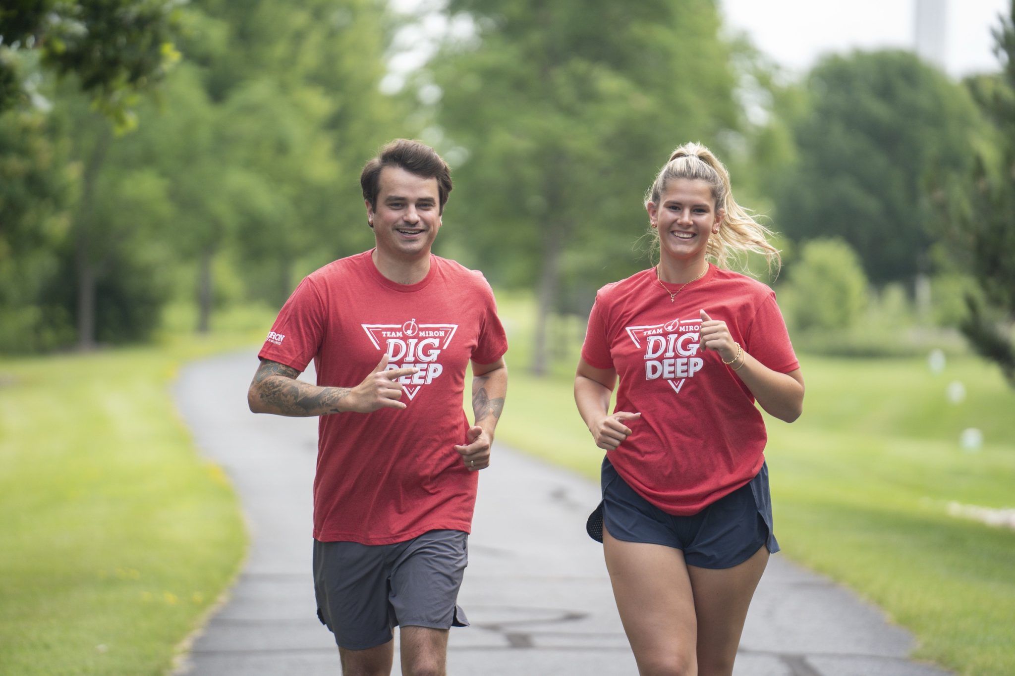 Two Miron runners in Dig Deep shirts running on a trail