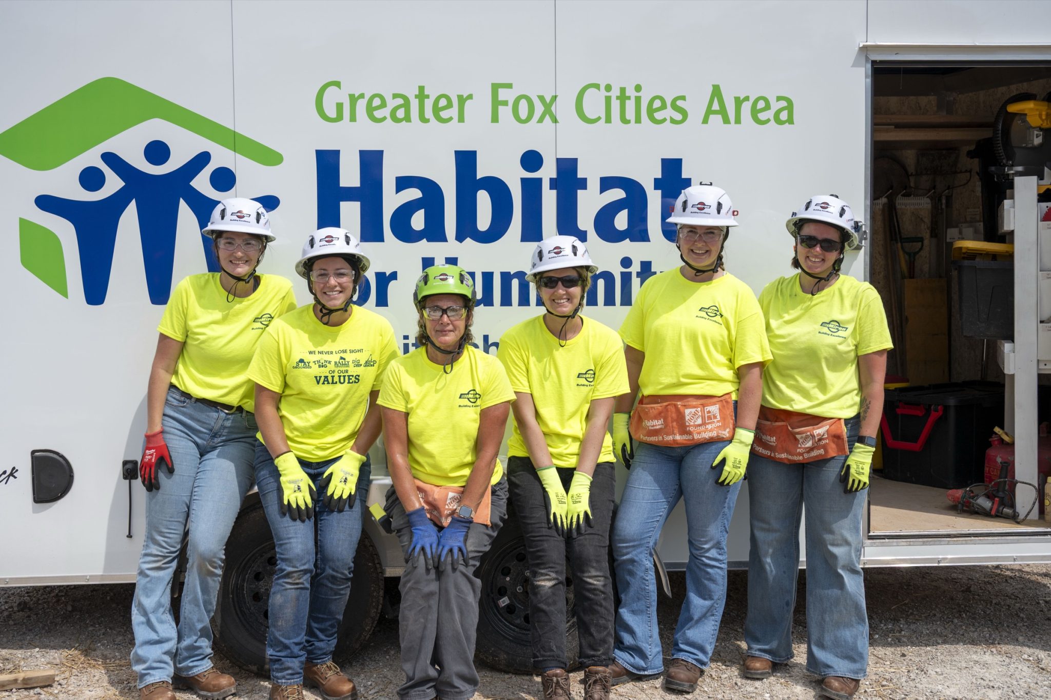 Miron volunteers in front of a Greater Fox Cities Area Habitat for Humanity trailer