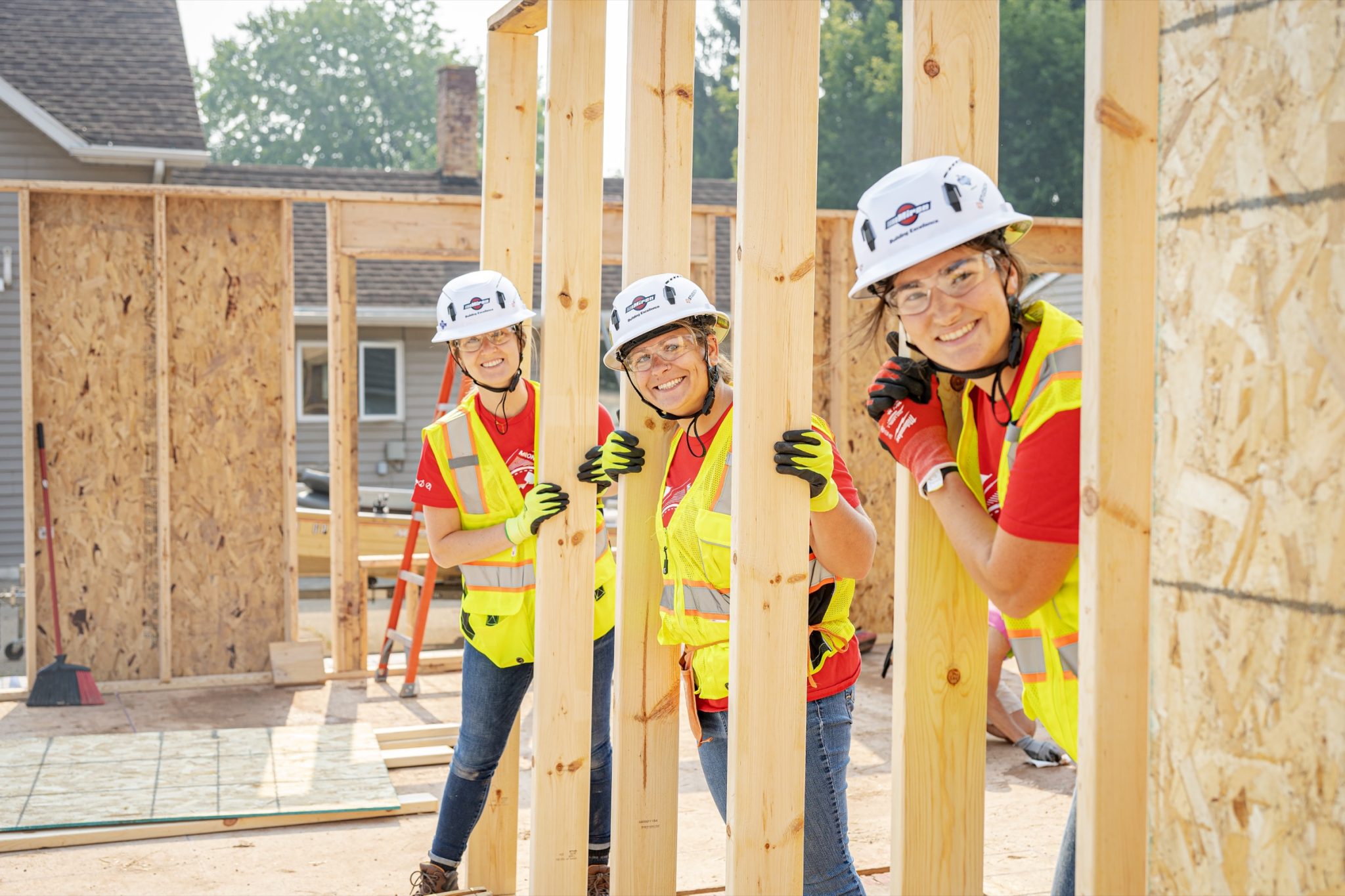 Miron volunteers in hard hats framing a Habitat for Humanity house