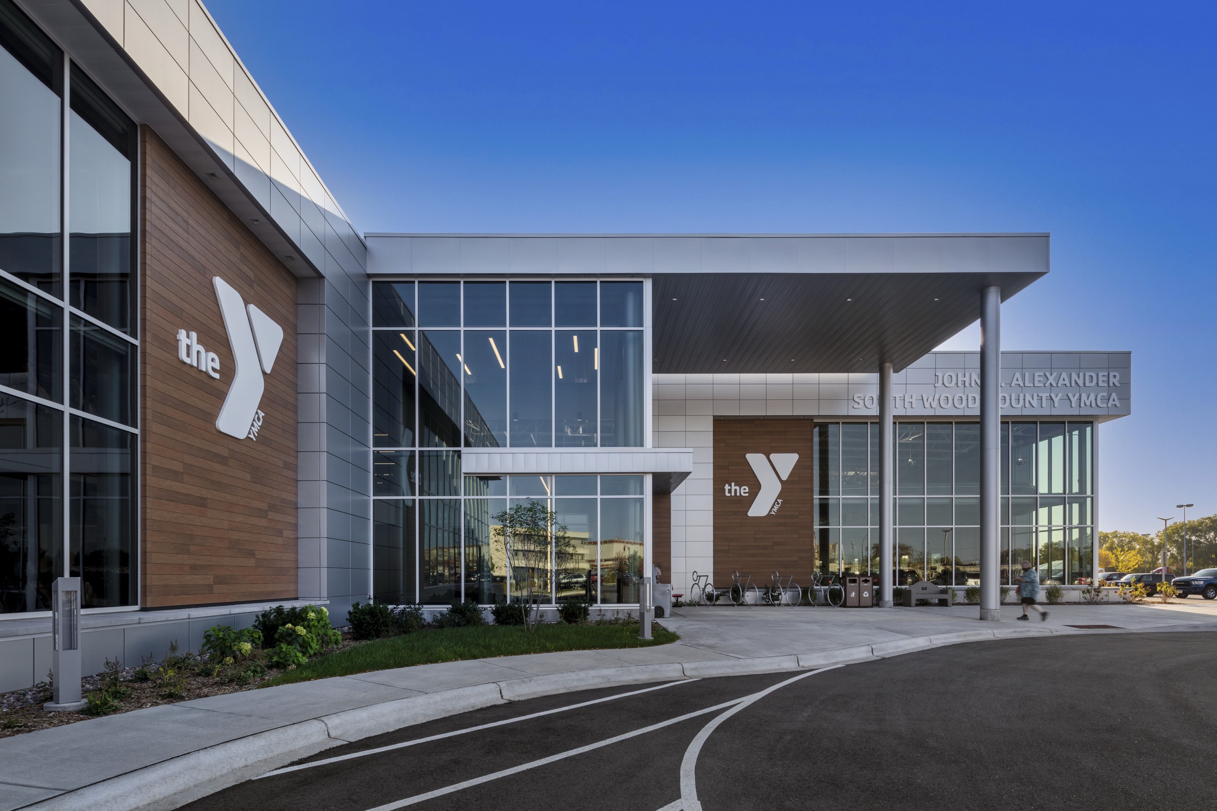 Glass entrance and canopy of the South Wood County YMCA at dusk