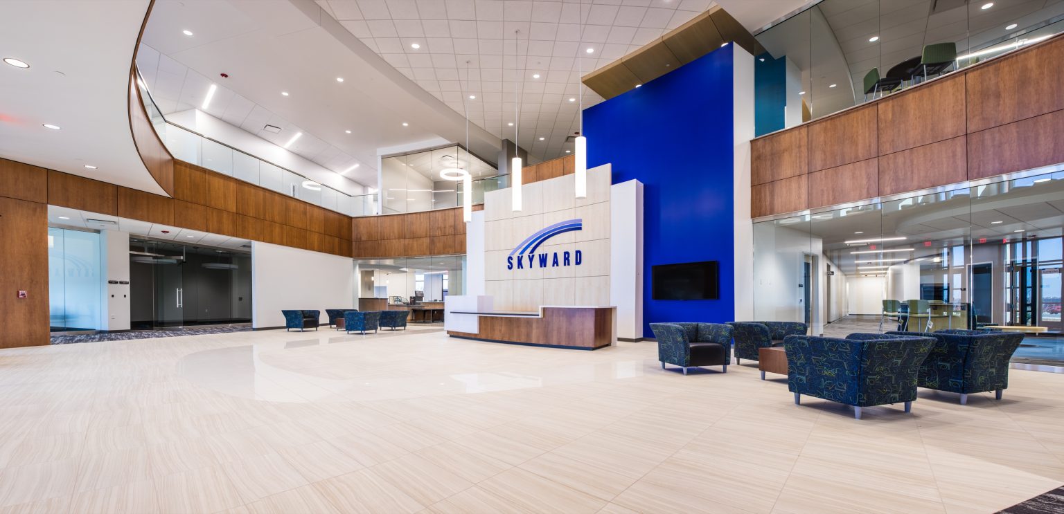 Bright two-story lobby at Skyward's corporate office with wood paneling and a blue feature wall