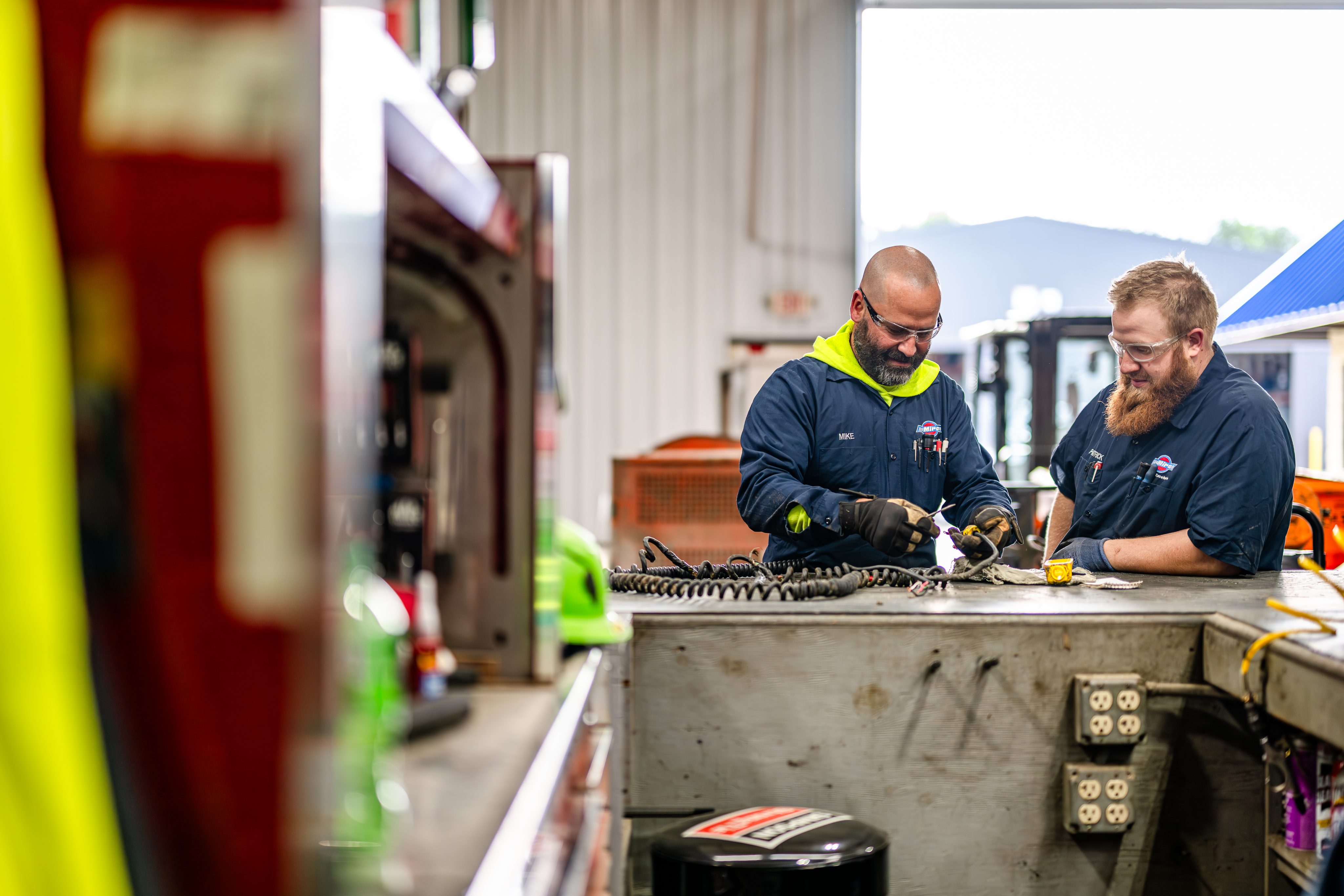Two Miron yard team members working together at a workbench in the shop