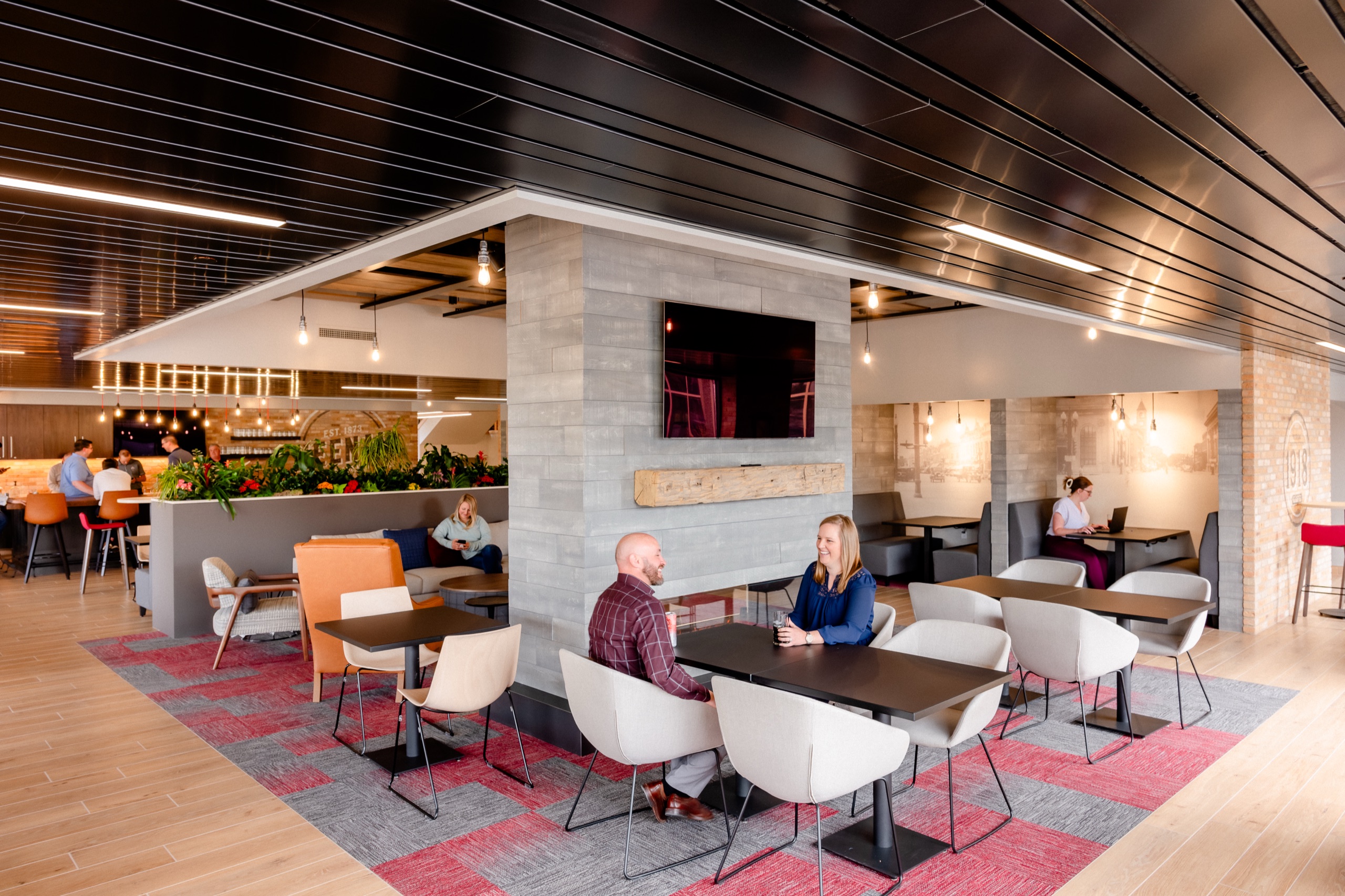 Two Miron employees talking at a table in a bright, modern office lounge