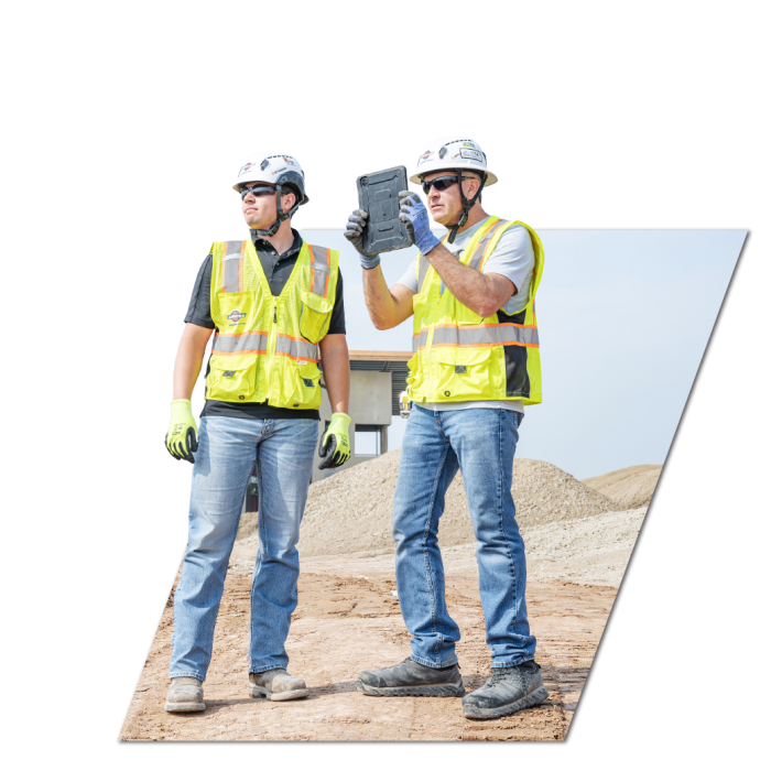 Project Manager and Superintendent at a job site with iPad in hand.